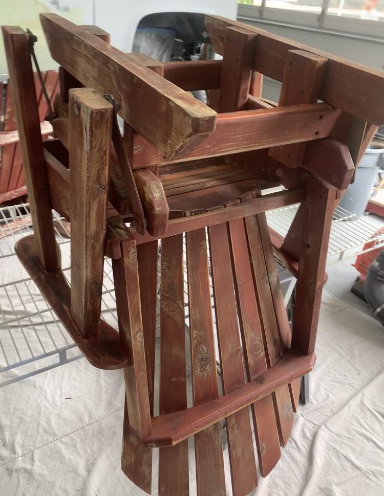 Stacked wooden chairs on a painted floor.