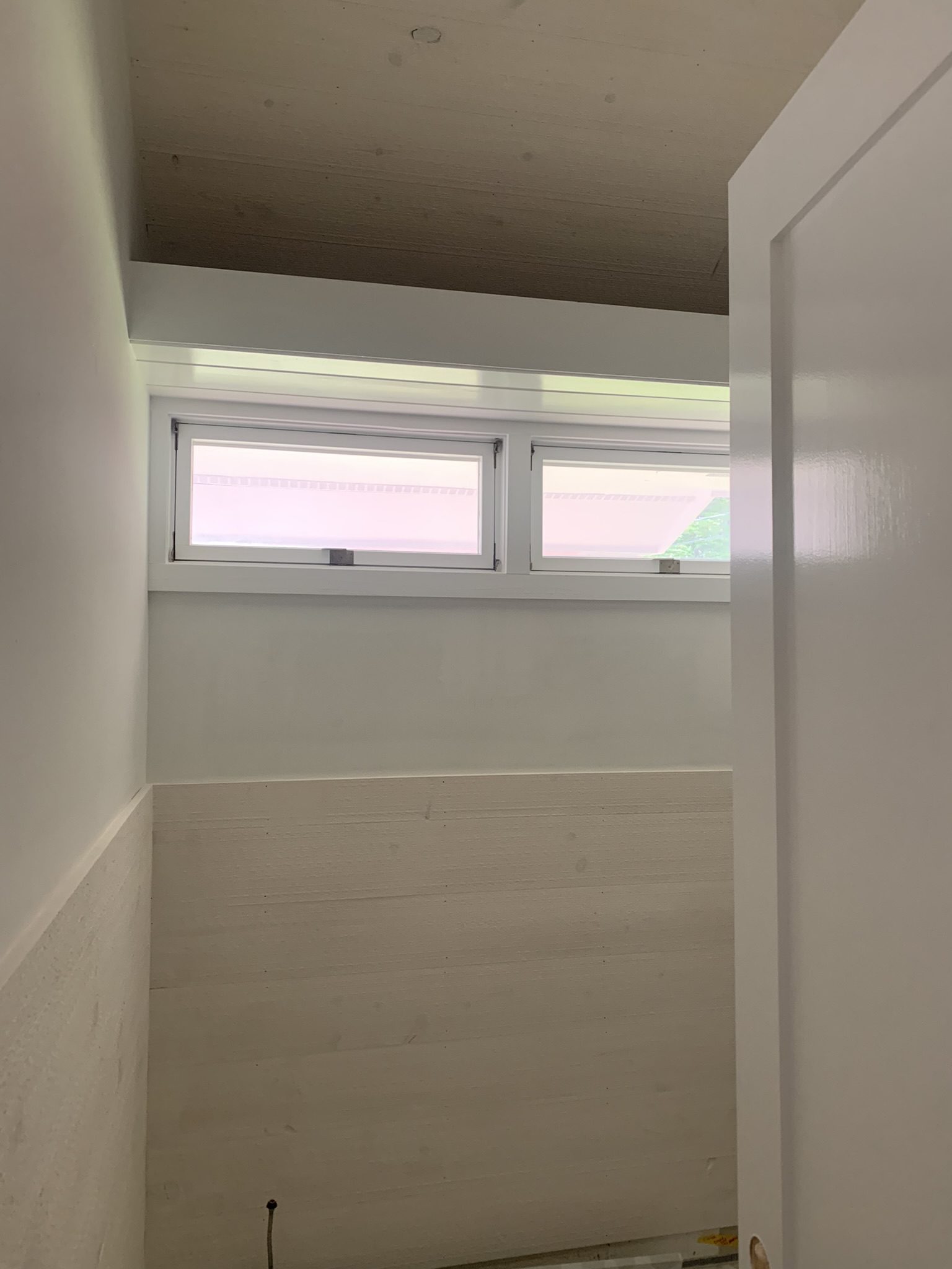 Small bathroom with high narrow windows.